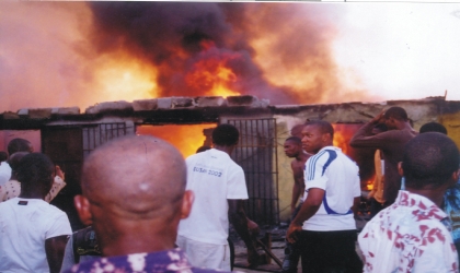 Victims and sympathizers watching the raging inferno opposite the Mile III Park, along Ikwerre Road, Port Harcourt, yesterday. Photo: Egberi Sampson