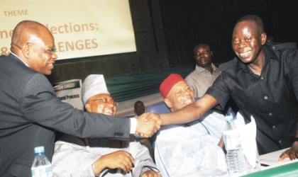 17031002 Chairman,Independent National Electoral Commission, Prof. Maurice Iwu (left) in a handshake with Gov. Adams Oshiomhole of Edo State, at the INEC National Conference for Stakeholders in the Electoral Process, in Abuja. With them Are, Representative of the Senate President, Sen. Isiaka Adeleke (2nd-left) and Chief Arthur Mbanefo.