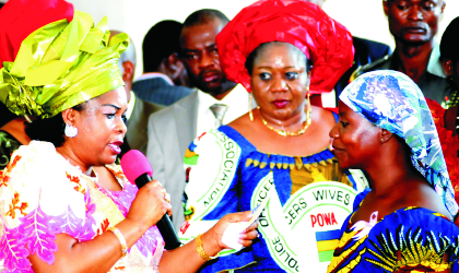 21041002 Wife of the Acting President, Mrs Patience Goodluck Jonathan, presenting a cheque to Mrs Martha Usman, member, Police Wives Association (PWA),at the seminar on Enhancing the Economic and Health Status of Police Families and Disbursement of Loans by NPF Micro Finance to POWA/PWA members in Abuja. With them is wife of AIG Zone 6, Mrs Filomina Ogboudu, last Monday.