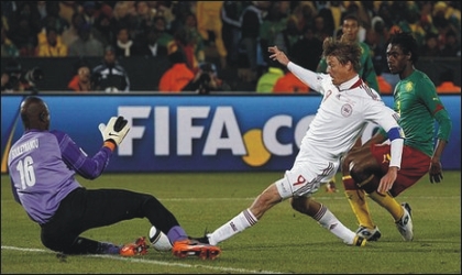 Denmark’s Jon Dahl Tomasson (9) trying to beat Cameroon’s keeper, yesterday.