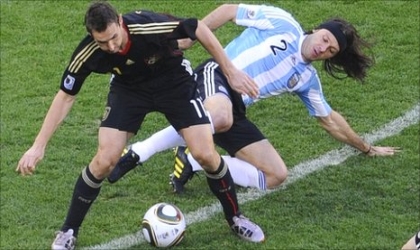 Germany’s Mroslav Klose (left) blocking off Argentina’s Demichelis on their quarter final clash in Cape Town, S’Africa, yesterday. Germany routed Argentina 4-0 to book their semi final sot in the 2010 World  Cup.