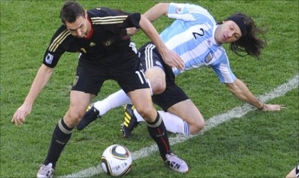 FRED04071001 Germany’s Mroslav Klose (left) blocking off Argentina’s Demichelis on their quarter final clash in Cape Town, S’Africa, yesterday. Germany routed Argentina 4-0 to book their semi final sot in the 2010 World Cup.