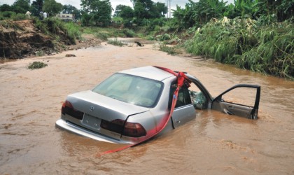 One of the two cars swept off the bridge at the Old Karmo River due to heavy down pour in Abuja, yesterday. Four occupants of the vehicles were confirmed dead.