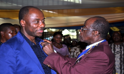 FRED18071001 Rivers State Governor, Rt. Hon. Chibuike Rotimi Amaechi (left) being decorated by Sir Gabriel Toby, District Governor of Rotary International, District 9140 during his investiture in Port Harcourt