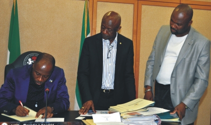 FRED19071002 Rivers State Governor, Rt. Hon. Chibuike Amaechi (left) signing five bills into law at the Executive Council Chambers of Government House, Port Harcourt, while State Attorney-General and Commissioner for Justice, Mr Ken Chikere (middle) and Leader, Rivers State House of Assembly, Hon. Chidi Lloyd, watch, recently.