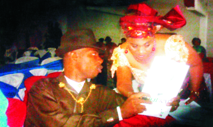 FRED25071002 President, Ijaw Youth Council (IYC), Miabiye Kuromiema, presenting some documents to the Master of Ceremony, Mrs Hilda Dokubo, during the inaugural ceremony of the IYC at the Diete-Spiff Civic Centre, Port Harcourt, yesterday.