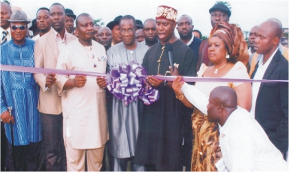 Governor of Rivers State, represented by state Commissioner for Works, Hon Dakuku Peterside (middle) being assisted by Deputy Speaker, Rivers State House of Assembly, Hon Dumnamene Deekor (3rd left) and Hon Maureen Tamuno, while cutting the tape during the commissioning of Tamuno’s constituency project in Ogu/Bolo LGA, on Tuesday.