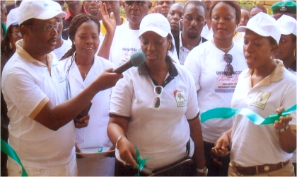 FRED24121003 Wife of Rivers State Governor, Mrs Judith Amaechi (middle) cutting the tape to commission 37 health centres of the 606060 Projects embarked upon by the state government, while wife of Deputy Governor, Dr Mina T. Ikuru (right) and State Commissioner for Health, Dr Sampson Parker (left), watch, at Rumuepirikom in Obio/Akpor LGA, on Monday. Photo: Nwiuh Donatus Ken