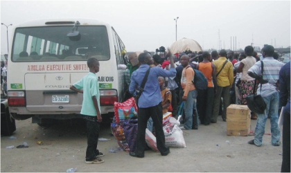 FRED27121003 Passengers struggling to board a bus at Mile I Motorpark in Port Harcourt on Christmas Day.