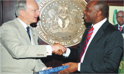 Governor Chibuike  Rotimi Amaechi (right) handing over a souvenir to Mr Henry Bellingham, United Kingdom Minister for Africa, during a courtesy visit to the governor at Government House, Port Harcourt.