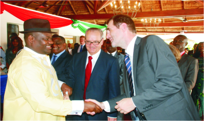 FRED18071103 Rivers State Deputy Governor, Engr. Tele Ikuru (left), in a handshake with the deputy Managing Director, Port Harcourt, Total Exploration and Production, Nigeria, Mr. Dennis Berthelot, while, the French Ambassador to Nigeria, Mr. Jean Michel-Dummond, watches delightfully.