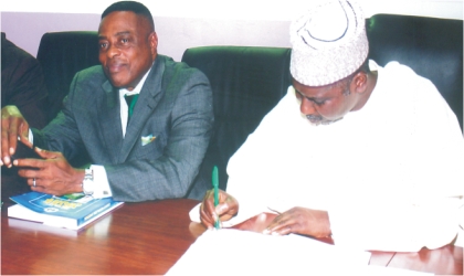 Chairman, Rivers State Independent Electoral Commission, Prof Nimi Briggs (left) watching as Director-General, National Institute of Policy and Strategic Studies, Kuru, Jos, Prof Tijani Bande signs the visitors notebook, when members of the Institute visited RSIEC, yesterday. Photo: Chris Monyanaga