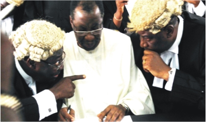Former Governor of Ogun State, Chief  Gbenga Daniels (middle) chatting with his lead Counsel, Prof.  Taiwo Osipitan(SAN) (left)  and  Mr Tayo Oyetubo,  at the Ogun State High Court during the arraignment of the former governor, Wednesday.