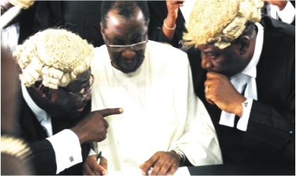 FRED14101102 Former Governor of Ogun State, Chief Gbenga Daniels (middle) chatting with his lead Counsel, Prof. Taiwo Osipitan(SAN) (left) and Mr Tayo Oyetubo, at the Ogun State High Court during the arraignment of the former governor, Wednesday.