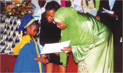 Representative of the First Lady and wife of the Vice President, Hajiya Amina Sambo (right supported by the Initiator, of Empowerement Support Initiative and wife of Rivers State Governor, Dame Judith Amaechi presenting a certificate to a kindergarten graduand in Port Harcourt, on Wednesday.