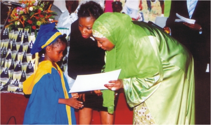 FRED28101103 Representative of the First Lady and wife of the Vice President, Hajiya Amina Sambo (right supported by the Initiator, of Empowerement Support Initiative and wife of Rivers State Governor, Dame Judith Amaechi presenting a certificate to a kindergarten graduand in Port Harcourt, on Wednesday.