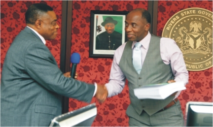 FRED25111101 Rivers State Governor, Rt. Hon. Chibuike Amaechi (right) receiving a report from the Chairman, Rivers State Independent Electoral Commission (RSIEC), Prof. Nimi Briggs during the commission’s presentation of end of tenure report at Government House, Port Harcourt, yesterday.