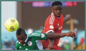 Super Eagles Brown Ideye (left) being checked by a Kenyan defender, during their first leg clash in Calabar