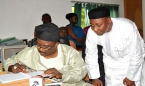 Chairman, Senate Committee on FCT. Senator Smart Adeyemi, signing a condolence register at the NUJ Secretariat in Abuja in honour of three journalists who died in an auto crash, last tuesday. With him is the NUJ President Malam Garba Mohammed.