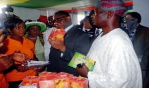 Minister of Trade and Investment, Dr Olusegun Aganga (middle), inspecting a product at one of the exhibition stands, during the opening ceremony of Lagos International Trade Fair in Lagos, last Friday. With him is the representative of the Governor, Mr Wale Raji (right).