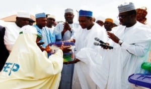 Former Minister of State for Health, Dr Muhammed Pate (2nd-right) presenting midwifery kits to beneficiary, Hajia Zainab Umar, during the Sure-P Subsidy Reinvestment and empowerment conditional cash transfer pilot programme in Soro Ganjuwa Lga of Bauchi State last Saturday. With them are the executive chairman, Bauchi State Primary Health Care Development Agency, Dr Nisser Ali  (right) Deputy Governor of Bauchi State, Alhaji Sagir Saleh (3rd-right). Photo: NAN