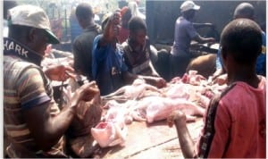 Men processing chicken for Christmas at Wuse Market in Abuja, yesterday.