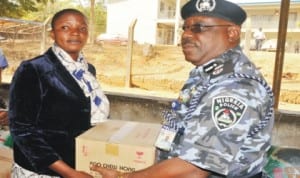 Representative of IGP, Mr Chris Olakpe (right), presenting food items on behalf of IGP to one of the widows of police officers that lost their lives on duty, Mrs Nandi Peter, during the presentation of food items to the widows in Jos last Monday.