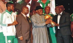 President Goodluck Jonathan (3rd left) receiving the 2013 AFCON trophy from Minister of Sports Malam Bolaji Abduallahi after the Eagles trumph in South Africa in February