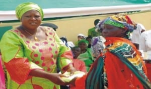 Wife of the Chairman, Kuje Area Council, Mrs Hannatu Shaban (left), presenting gift to aged women, through Mrs Saratu Shekwolo, during a party with orphans, widows and aged women in Kuje last Wednesday. Photo: NAN