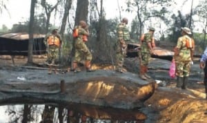 Securitymen supervising the destruction of illegal oil refineries at Alakiri in Okirika Local Government Area, of Rivers State last Thursday