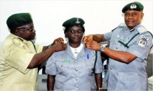 L-R: Assistant Comptroller-General of Prisons, Bauchi State, Alhaji Adamu Balami and Zonal Co-ordinator, Nigeria Customs Service, Zone 'D', Mr Ukaigwe Paul, decorating Mrs Cecilia Ajaenu with her new rank of Chief Superintendent of Customs in Bauchi last Wednesday. Photo: NAN