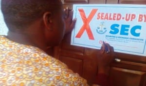 Official of Security and Exchange Commission (Sec) sealing off a premises used by a Private Capital Market operator for operating a Ponzi scheme in Calabar last Tuesday. Photo: NAN
