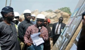 Governor Babatunde Fashola of Lagos State (left), listening to the Permanent Secretary,  state Ministry of Environment, Mr Akeem Ogunbanbi (middle),  during the inspection of Agbowa Residential Estate for flood victims in Lagos last Thursday