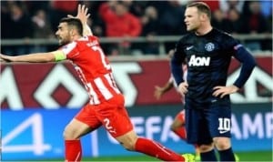 Man Utd’s Wayne Rooney (10) astounded as Olympiakos’ skipper celebrates one of their goals against the English Champions last night in Athens