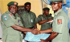 Commandant, Nigerian Army School of Public Relations and Information, Col. Rabe Abubakar (left), presenting a gift to the overall best student of the school's Young Officers Course 4, Capt. Sydney Mbaneme, at the graduation in Lagos, last Wednesday