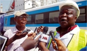 Representative of the Managing Director, Nigeria Railway Corporation (NRC), Mr Fidel Okhiria (right), speaking to newsmen during the off-loading of newly acquired air-conditioned long distance coaches and diesel multiple units at the Apapa Port Complex, last Friday. Left is Assistant Director, Public Relations Office, NRC, Mr David Ndakotsu.
