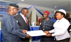 Cross River State Governor, Senator Liyel Imoke (left), presenting a cheque to one of the beneficiary communities of the N470million development grant while the DG of CRSDA, Pastor Ovat (2nd left), watches in Calabar, recently.