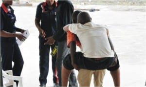 One of the candidates being helped to the hall for the unified tertiary matriculation examination in Abuja, last Saturday 