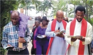 Rivers State Governor, Chibuike Amaechi (left with a cross) participating in Good Friday Stations of the Cross. The hooded cross on his left shoulder is symbolic.