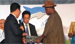 Rivers State Governor, Rt Hon Chibuike Amaechi (right), receiving Port Harcourt World Book Capital 2014 from Deputy Governor, Bangkok, Mr K  Amond (left), during the celebration of the Port Harcourt World Book Capital, at Hotel Presidential, Port Harcourt, Wednesday. With them is A representative of Bangkok