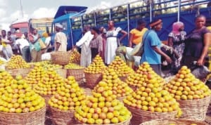 Women buying mangoes at Zuba Fruit Market in Abuja last Saturday. Photo: NAN