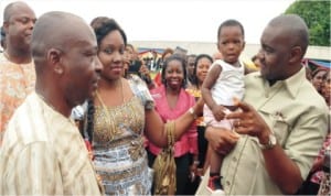 Sen. Magnus Abe with a little baby (right), his wife Bariyaah (centre) and Chairman, Khana LGA, Gregory Nwidam during the presentation of wrappers to 1,900 women in Bori, recently.