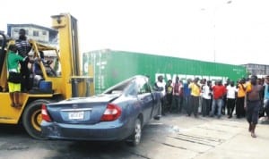 One of the vehicles involved in an accident, where a truck carrying a container fell on two cars, at Idi-Oro Bus Stop, Mushin, in Lagos, last Sunday. Photo: NAN