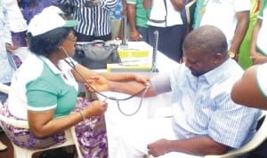 President, World Medical Association, Dr Margaret Mungherera (left), taking the blood pressure of the chairman, Egor Local Government Council, Mr Victor Enobakhare, during Nigeria Medical Association (NMA) free medical treatment in Evbuotubu community, Benin-City in Edo State last Wednesday. 