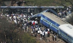 People gather around a derailed passenger train in India