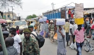 People doing  Business  under the protection of soldiers in Maiduguri last Saturday. Photo: NAN