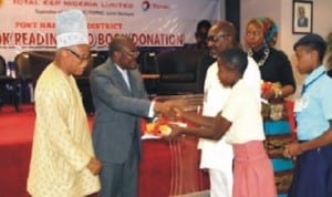 Executive General Manager, Administration, Total E and P Nigeria Limited, Mr. Peter Igbinovia (left), Permanent Secretary, Rivers State Ministry of Education, Mr. Michael West (2nd left), presenting books to one of the representatives of the schools, at the 2014 Book Reading/Book Donation ceremony organised by Total in Port Harcourt, recently.