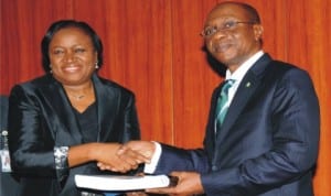 New CBN Governor, Mr Godwin Emefiele (right),  receiving a hand over note from the  Acting Governor, Dr Sarah Alade in Abuja, yesterday.
