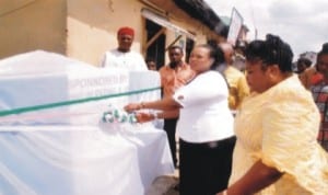 Wife of former member of Rivers State House of Assembly, Mrs Oroma Nmerukini (middle) cutting a tape to commission a water project   initiated by a federal lawmaker in Mile 1, Rumuwoji community, Port Harcourt, recently.  With her is the initiator of the project and member, House of Representatives, Mrs Blessing Boma Nsiegbe