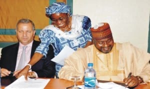 Minister of State for Power, Mr Mohammed Wakil (right), with team leader of American investors, Mr Roy Tefeez (left), signing a Memorandum of Understanding on power in Abuja last Monday. With them is Director, Legal Services, Ministry of Power, Mrs Adedotun Shoetan.